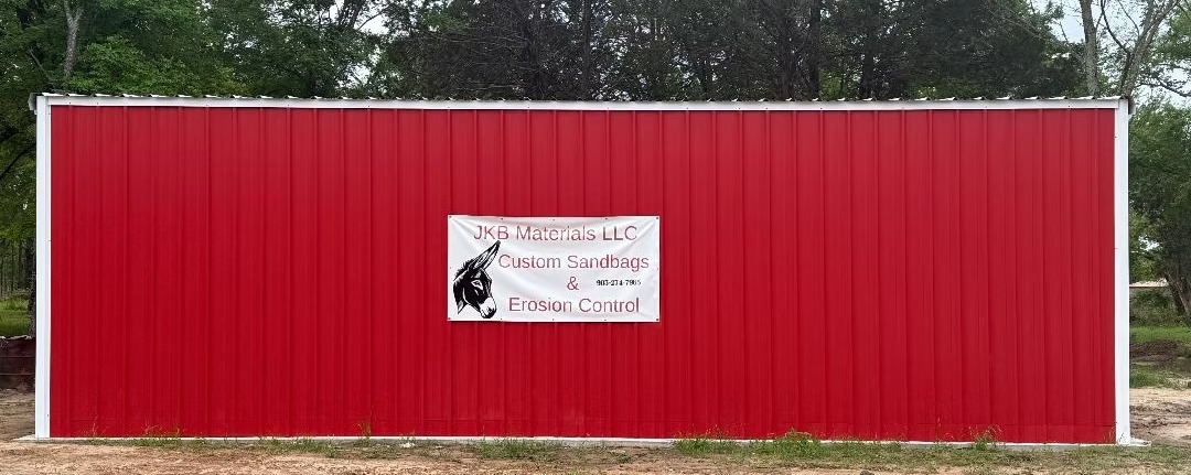 JKB Materials red building and custom sandbags sign in Emory, TX